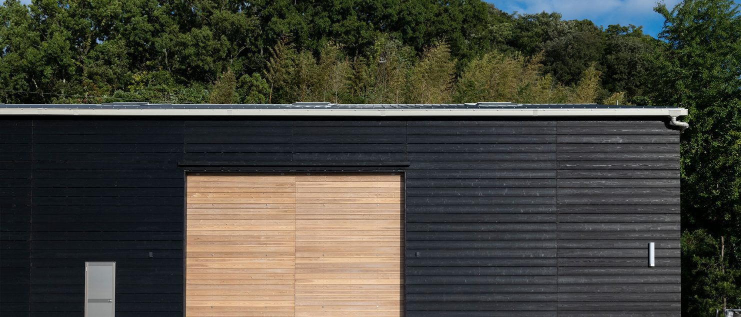 Industrial building facade with Yakisugi a.k.a Shousugiban cedar cladding and large timber door.