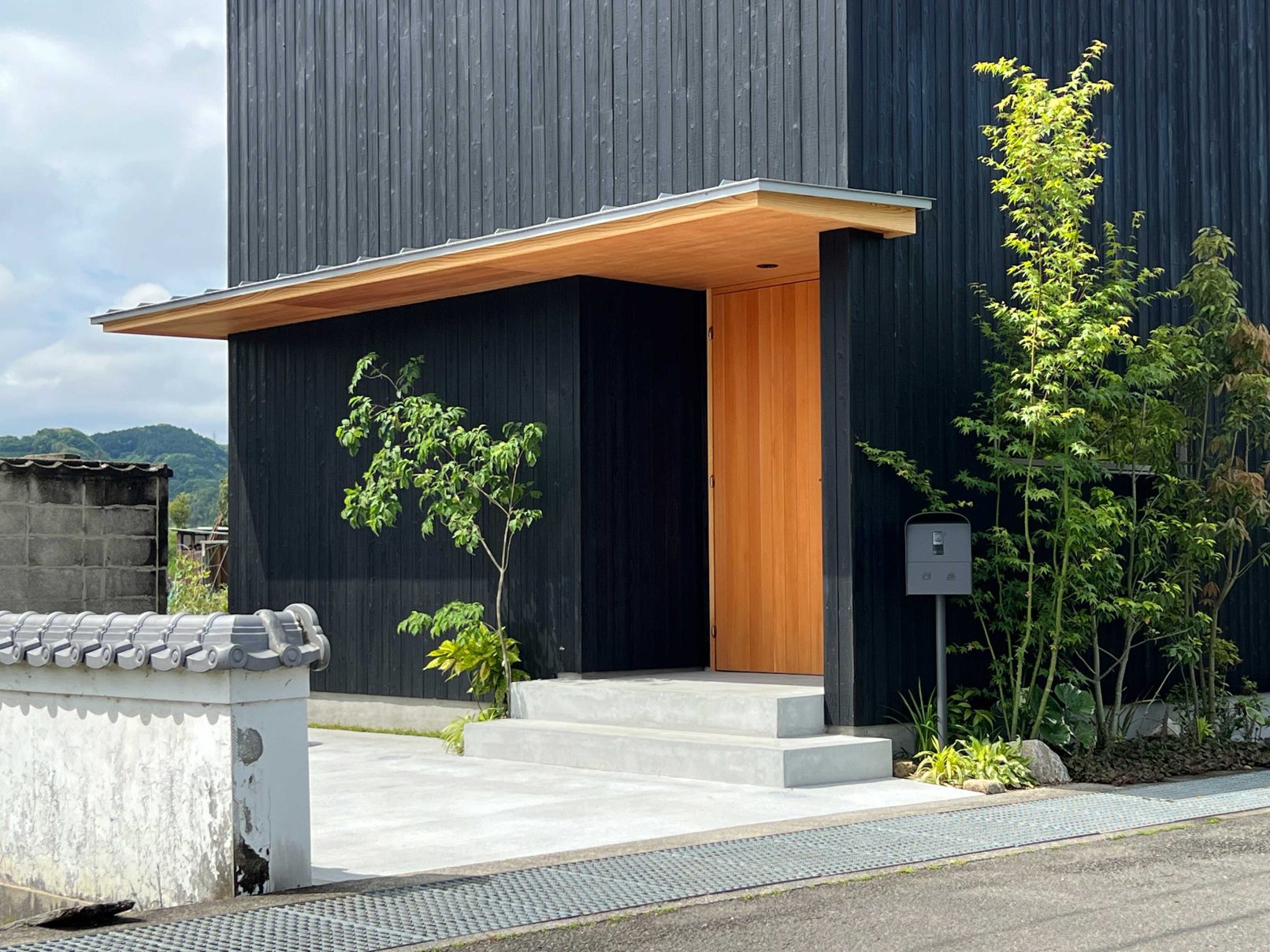 Modern house entrance with Yakisugi a.k.a Shousugiban charred cedar cladding.