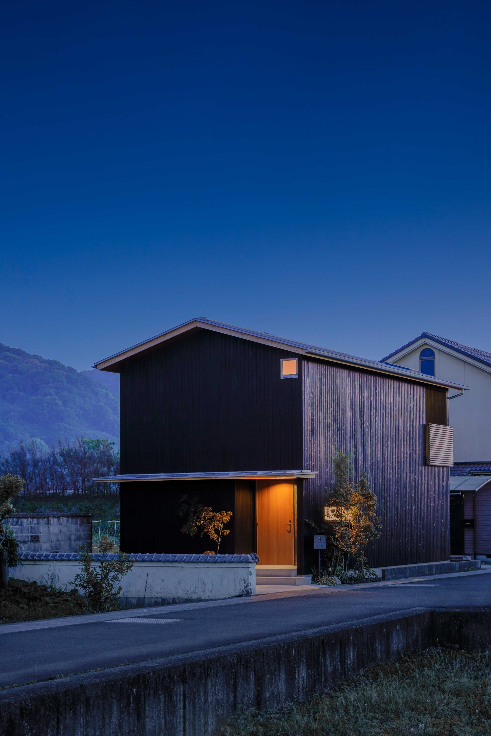 Modern house exterior with Yakisugi a.k.a Shousugiban charred cedar cladding at twilight.