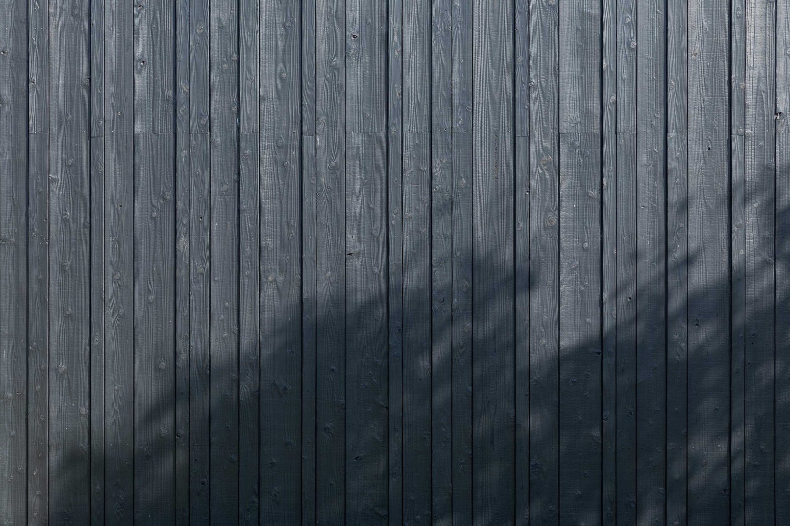 Vertical Yakisugi a.k.a Shousugiban charred cedar cladding wall with natural wood grain.
