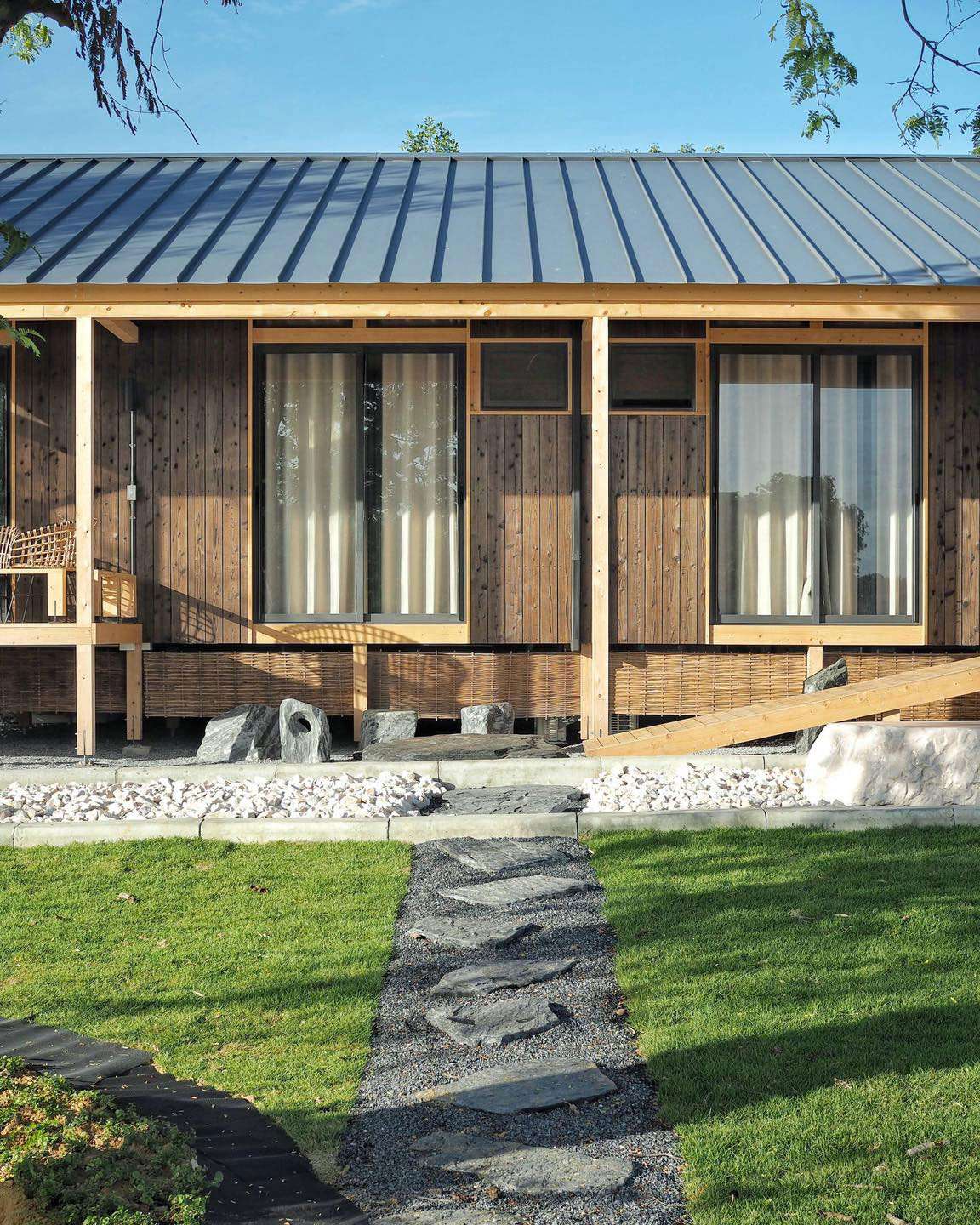 Modern house with Yakisugi a.k.a Shousugiban cedar cladding and garden pathway.