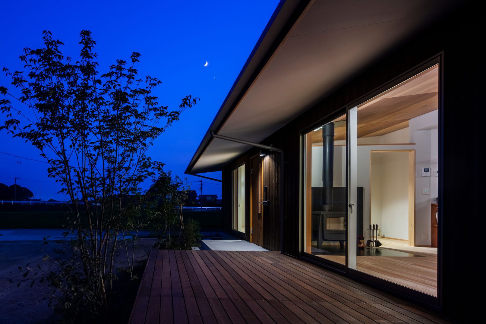 Modern house with Yakisugi a.k.a Shousugiban cedar cladding illuminated at night.